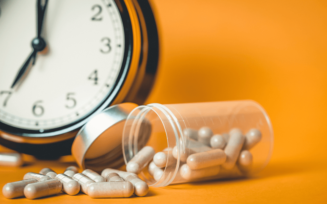 medicinal mushroom supplements in capsules next to a clock